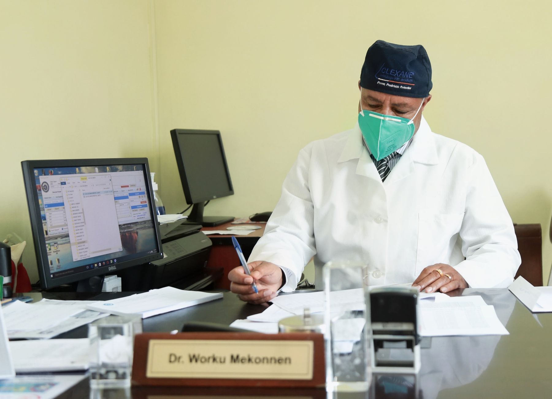 A doctor completing patient paperwork at his desk