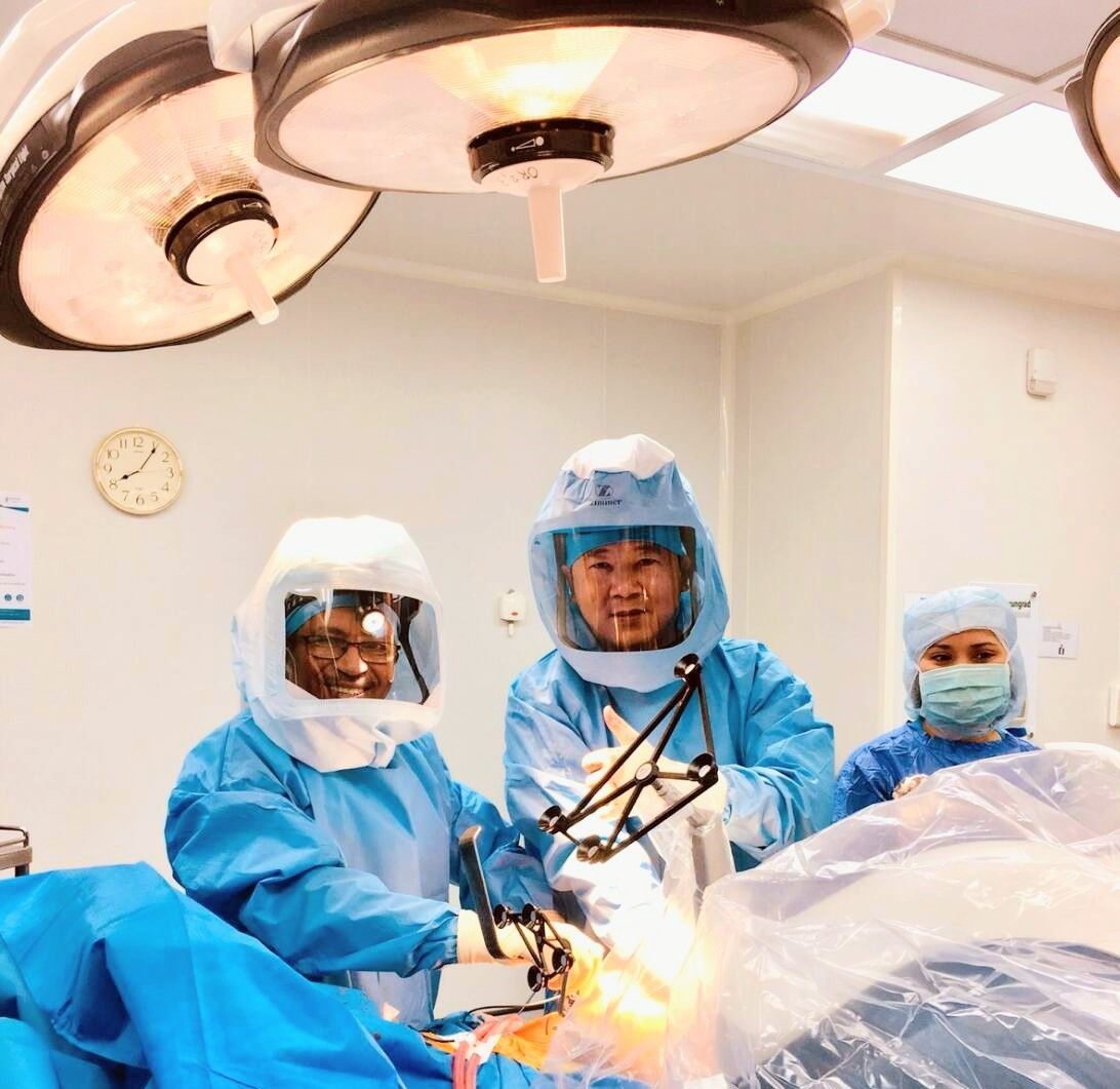 Surgeons in full sterile gowns performing joint surgery