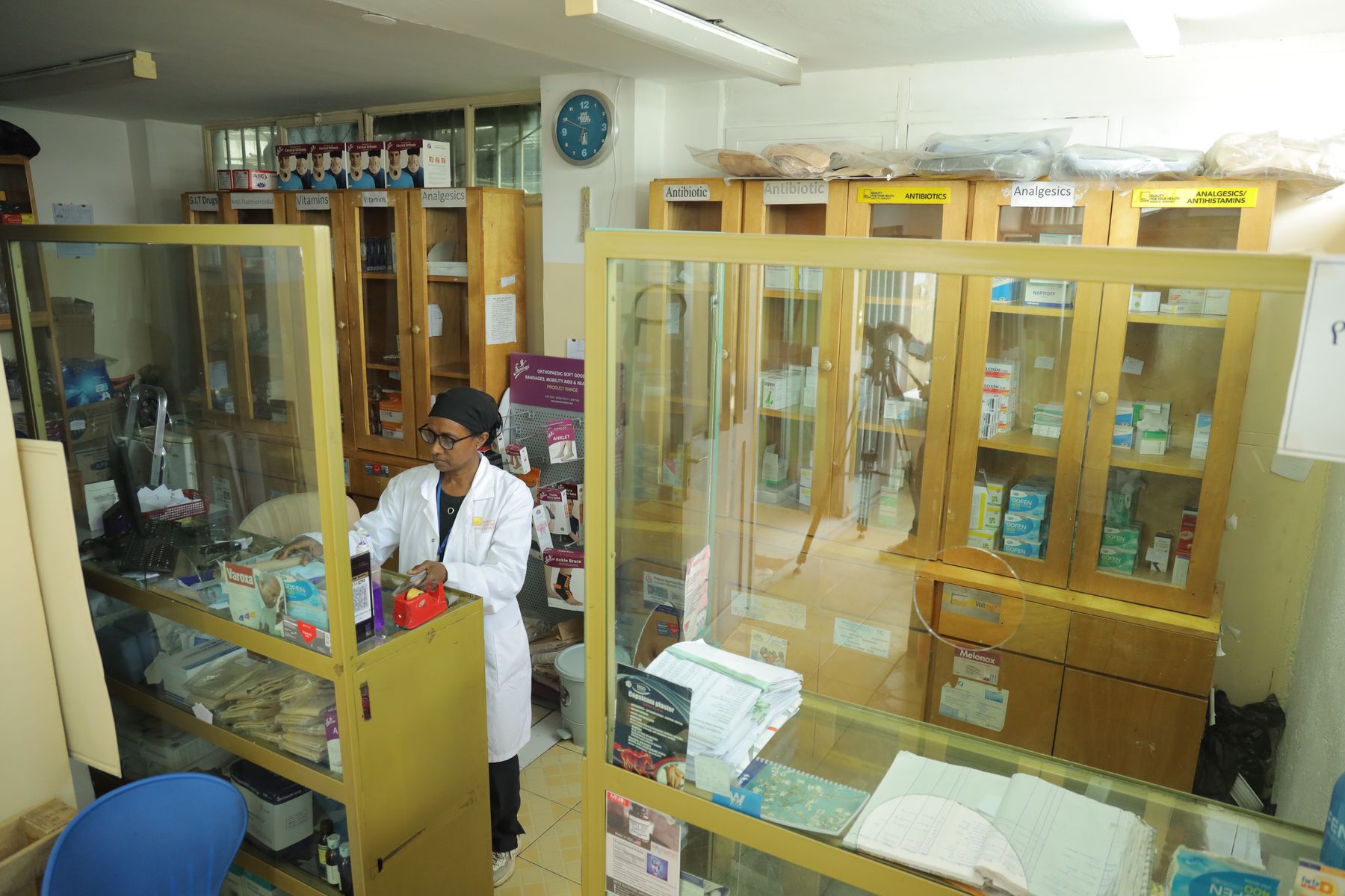 The hospital pharmacy with a pharmacist at the dispensing counter
