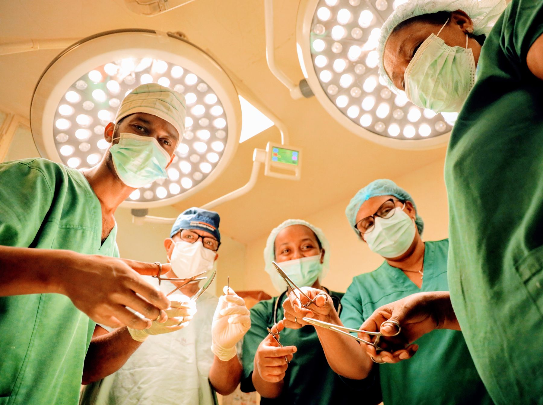 Surgeons and nurses operating under the theatre lights, seen from below