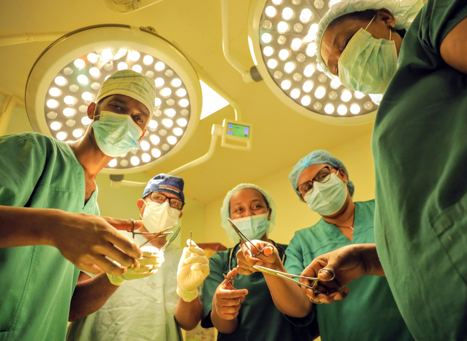 Surgeons and nurses operating under the theatre lights at Yordanos Hospital